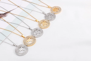 Detail of assorted gold and silver titanium steel necklaces with hollow tree of life pendants