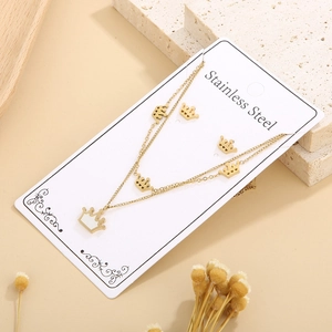 Detail of gold stainless steel crown necklace and earrings set on a display card