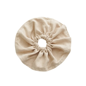 Oversized beige fabric scrunchie with stitched edges on a clean white background