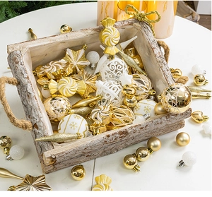 Detailed view of festive gold and white Christmas ornaments in a rustic wooden tray