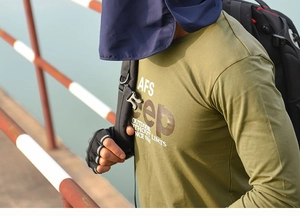 Outdoor male model wearing army green long sleeve shirt with backpack and sun hat outdoors