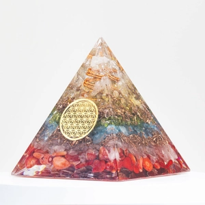 Detail of crystal pyramid with flower of life symbol, copper coil and colorful gemstones
