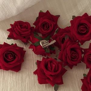 Detailed view of handmade silk red rose hair clips with metal duckbill backings