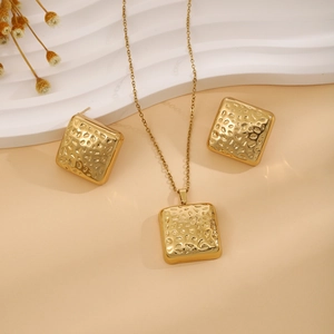 Detail shot of golden square jewelry set with elegant hammered texture finish