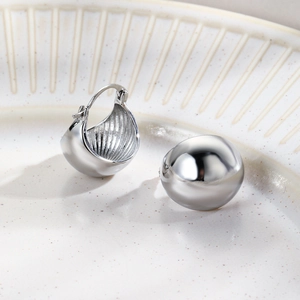 Detailed macro view of silver dome hoop earrings with high-gloss mirror polished finish