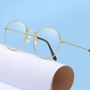 Vintage round gold metal eyeglasses frame for men and women on a light blue background