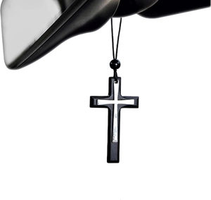 Detailaufnahme des doppellagigen Vintage-Metallkreuz-Anhängers am Autorückspiegel hängend