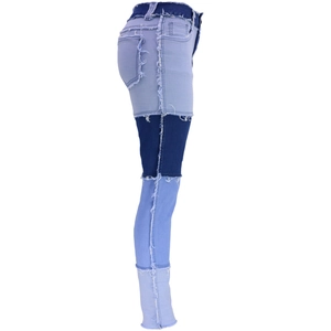 Dettaglio dei jeans patchwork con bordi sfrangiati grezzi e design a vita alta