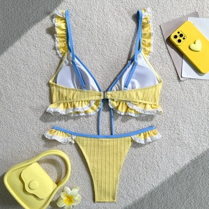 Close-up of yellow ribbed bikini with blue trim and white lace ruffles detail