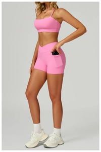 Détail du short de yoga rose à taille haute avec poche latérale et design croisé à la taille