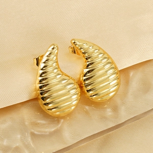 Chic gold-plated drop earrings with ribbed texture on champagne silk background