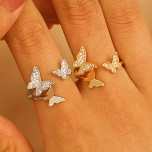 Detailed view of copper ring with two butterflies featuring pavé crystals and polished finish