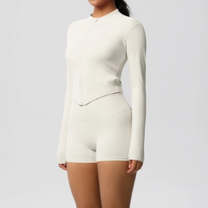 Detail of cream long sleeve zip yoga jacket with V-shape hem and high waist biker shorts