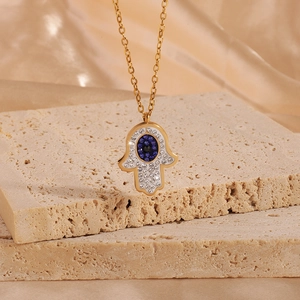 Gold Hamsa Hand necklace with blue evil eye pendant and sparkling zircon crystals