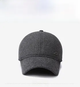 Detailed macro view of dark grey herringbone wool texture and mountain metal logo on cap