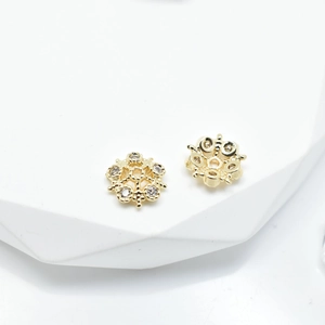 Detailed macro view of 18k gold plated snowflake flower spacers with inset cubic zirconia