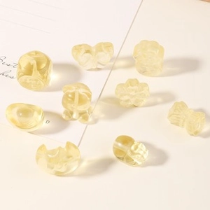 Macro detail of 14k gold-filled strawberry crystal beads in cat and flower shapes