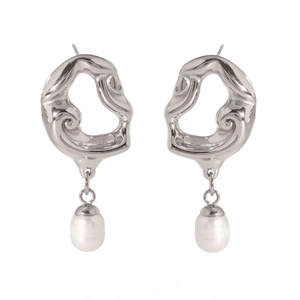 Détail de boucles d'oreilles cœur argenté ajouré avec élégants pendentifs en perles blanches