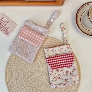 Detailed view of floral nurse pouch with dual layers and snap button hanging strap
