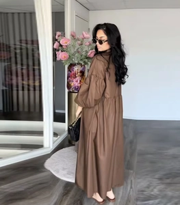 Detail of a brown puff sleeve maxi dress featuring a high waist and elegant loose silhouette