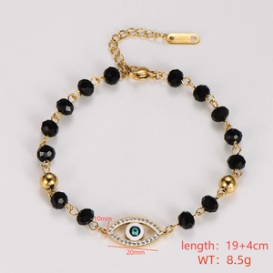 Detail of gold stainless steel bracelet with black faceted beads and evil eye charm