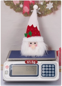 Detailed close-up of a Christmas plush candy doll on a scale weighing 61.5 grams