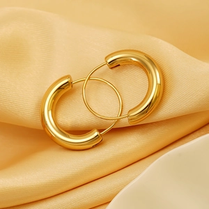 Classic 18K gold plated stainless steel hoop earrings on elegant yellow silk fabric