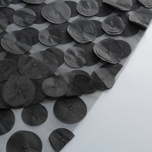 Detailed macro view of black 3D circular applique mesh fabric for tube dress