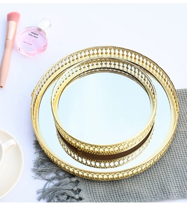 Detail view of round gold metal mirrored trays with hollow pattern for home decor