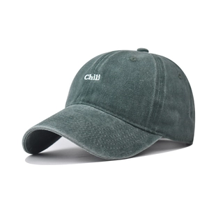 Detailed view of the white Chili embroidery and washed vintage texture on green cotton cap
