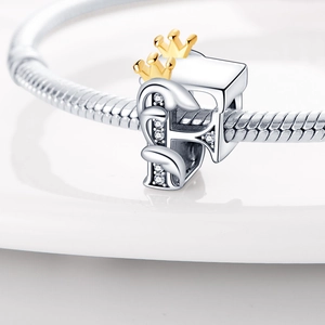 Detailed close-up of a silver letter F bead with a gold crown and cubic zirconia