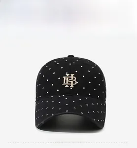 Front view of black washed cotton baseball cap with white polka dots and gold embroidery