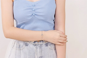 Detailed view of silver minimalist chain bracelet with hollow circular charm on wrist