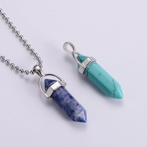Macro shot of blue and turquoise hexagonal crystal point pendants with beaded necklaces