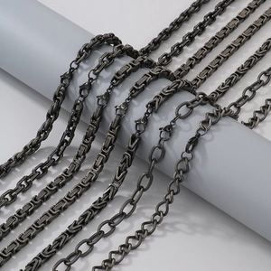Detail view of dark grey and black metal chain necklaces in various weaving styles