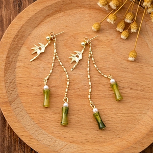 Detailed view of Chinese style long tassel earrings with green bamboo jade and gold leaf