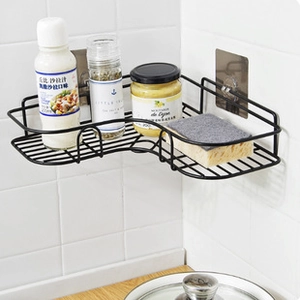 Close-up of a black metal corner shelf for kitchen storage with adhesive mounting hooks