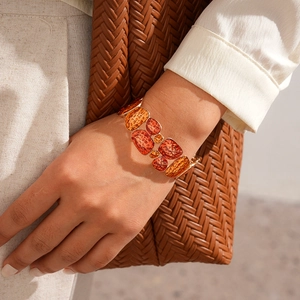 Close-up of bohemian stretch bracelet with orange geometric resin tiles and hammered texture