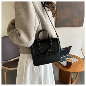 Chic black PU leather square bag with decorative plastic chain shown in cafe setting