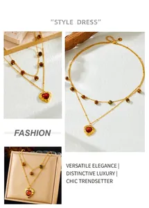 Detail of double-layer gold chain necklace with a heart gemstone pendant and beads