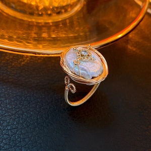 Macro di anello con perla barocca, dettagli a croce e montatura in filo dorato