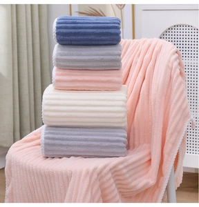 Close-up of soft coral fleece towels with vertical striped texture in multiple colors