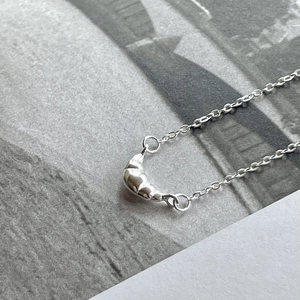Minimalist S925 sterling silver necklace featuring a polished croissant shaped pendant