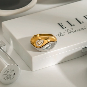 Modern two-tone stainless steel ring with double pear-cut crystals on a display box