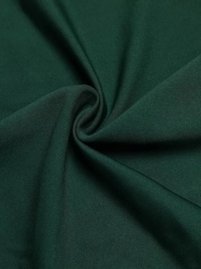 Macro detail of dark green knit fabric texture showing soft pleats and matte finish
