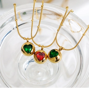 Détail de chaînes serpent dorées avec pendentifs sphériques et zircons en forme de cœur
