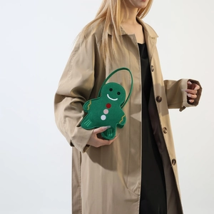 Green gingerbread man felt tote bag with cute buttons, held by a model in a trench coat