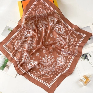 Detail of red-brown silk square scarf with white paisley pattern and elegant dotted border