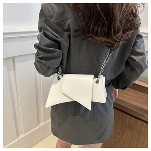 Gros plan d'un sac à bandoulière géométrique blanc avec chaîne en métal sur un modèle