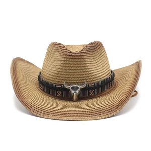 Détail d'un chapeau de paille western avec ruban ethnique et ornement de crâne de taureau